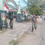 Beberapa prajurit dengan seragam PDL sedang membersihkan dedaunan.