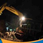 Petugas bersama BPBD membersihkan material longsor.