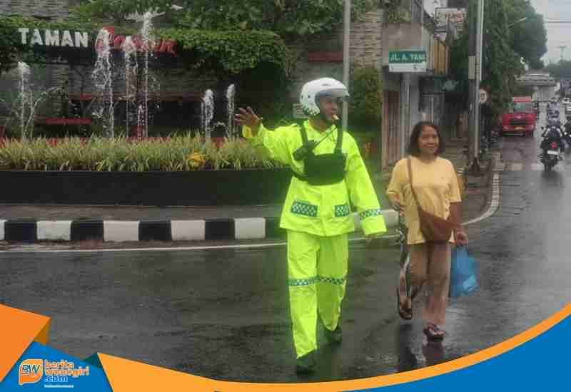 Personel Satlantas Polres Wonogiri melakukan pengaturan lalu lintas saat hujan di Jalan Sudirman