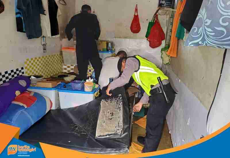 Polisi memeriksa tumpukan pakaian warga binaan di dalam kamar sel.