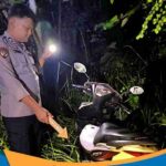 Sepeda motor Honda Spacy hitam putih terparkir di pinggir jalan hutan Desa Ngadipiro.