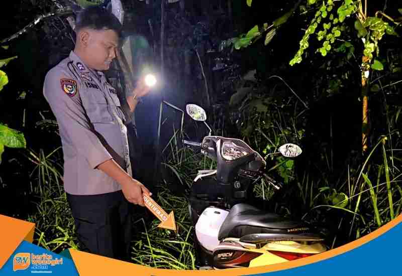 Sepeda motor Honda Spacy hitam putih terparkir di pinggir jalan hutan Desa Ngadipiro.