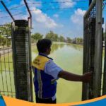 Petugas pengairan memeriksa pintu air irigasi di persawahan Tasikmadu.