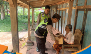 Bripka Joko Yutanto menyerahkan paket sembako kepada Ibu Mijem di Jatisrono.