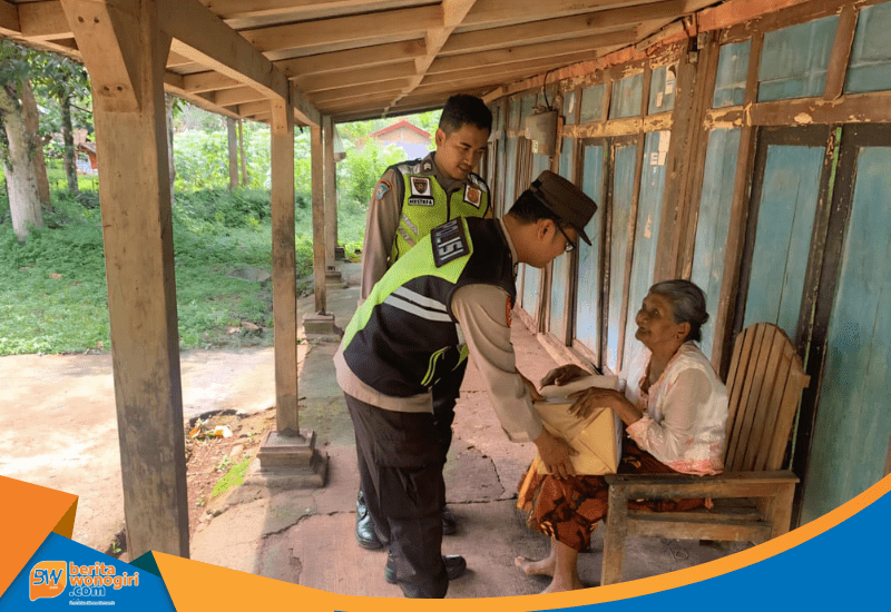Bripka Joko Yutanto menyerahkan paket sembako kepada Ibu Mijem di Jatisrono.