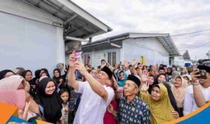 Gubernur Jateng Ahmad Luthfi memegang HP warga untuk melakukan foto bersama atau selfie di Huntara.