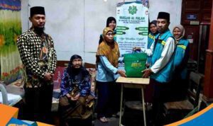 Lansia dhuafa tersenyum sumringah memegang bingkisan alat shalat baru berupa mukena dan sajadah.