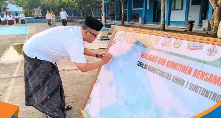 Kepala SMK Negeri 1 Giritontro Anggara Budi Laksono sedang menandatangani lembar dokumen deklarasi Sekolah Berintegritas